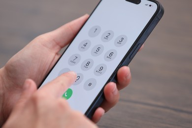 Photo of Woman dialing number on smartphone against blurred background, closeup