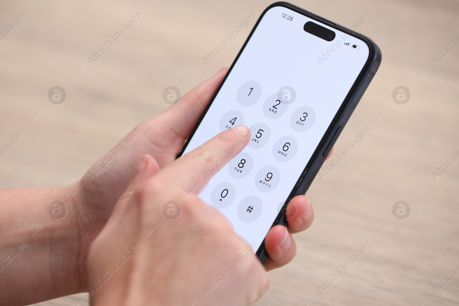 Photo of Woman dialing number on smartphone against blurred background, closeup