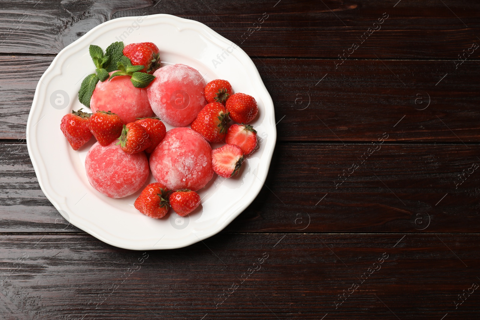 Photo of Delicious mochi, strawberries and mint on wooden table, top view. Space for text