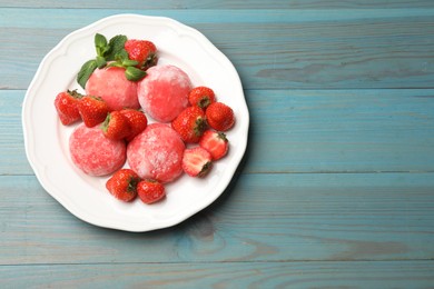 Photo of Delicious mochi, strawberries and mint on light blue wooden table, top view. Space for text