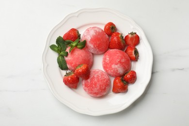 Photo of Delicious mochi, strawberries and mint on white marble table, top view