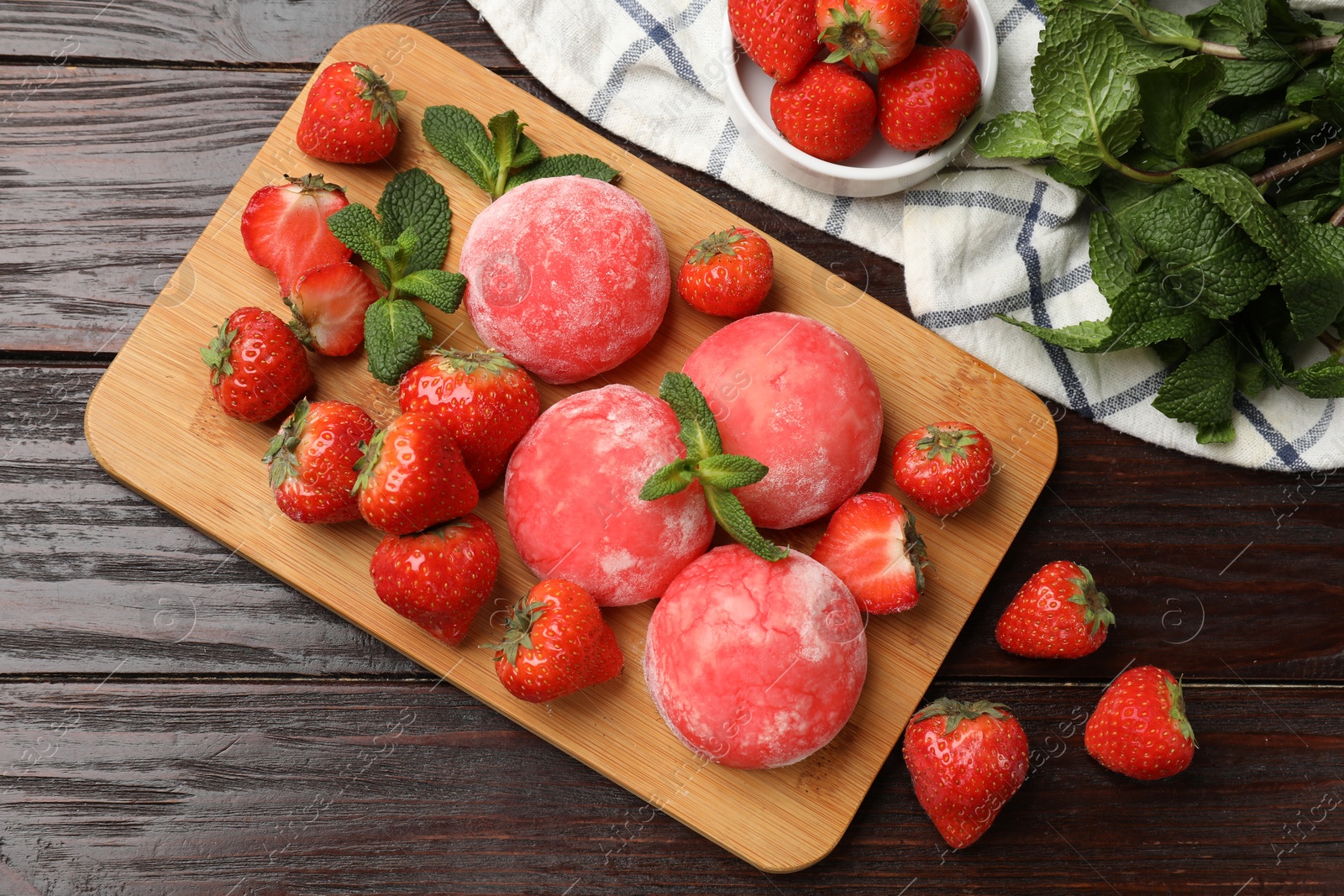 Photo of Delicious mochi, strawberries and mint on wooden table, flat lay