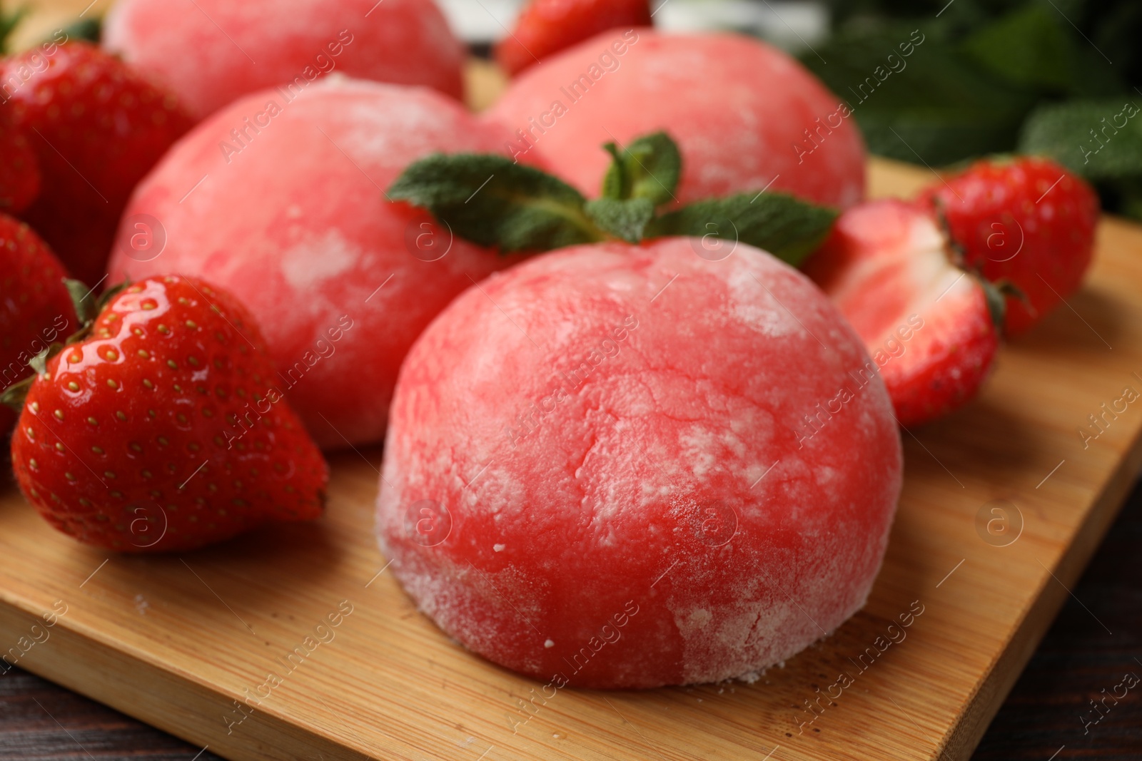 Photo of Delicious mochi, strawberries and mint on table, closeup