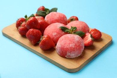 Photo of Delicious mochi, strawberries and mint on light blue background, closeup