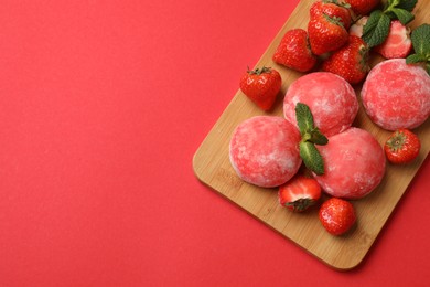 Photo of Delicious mochi, strawberries and mint on red background, top view. Space for text