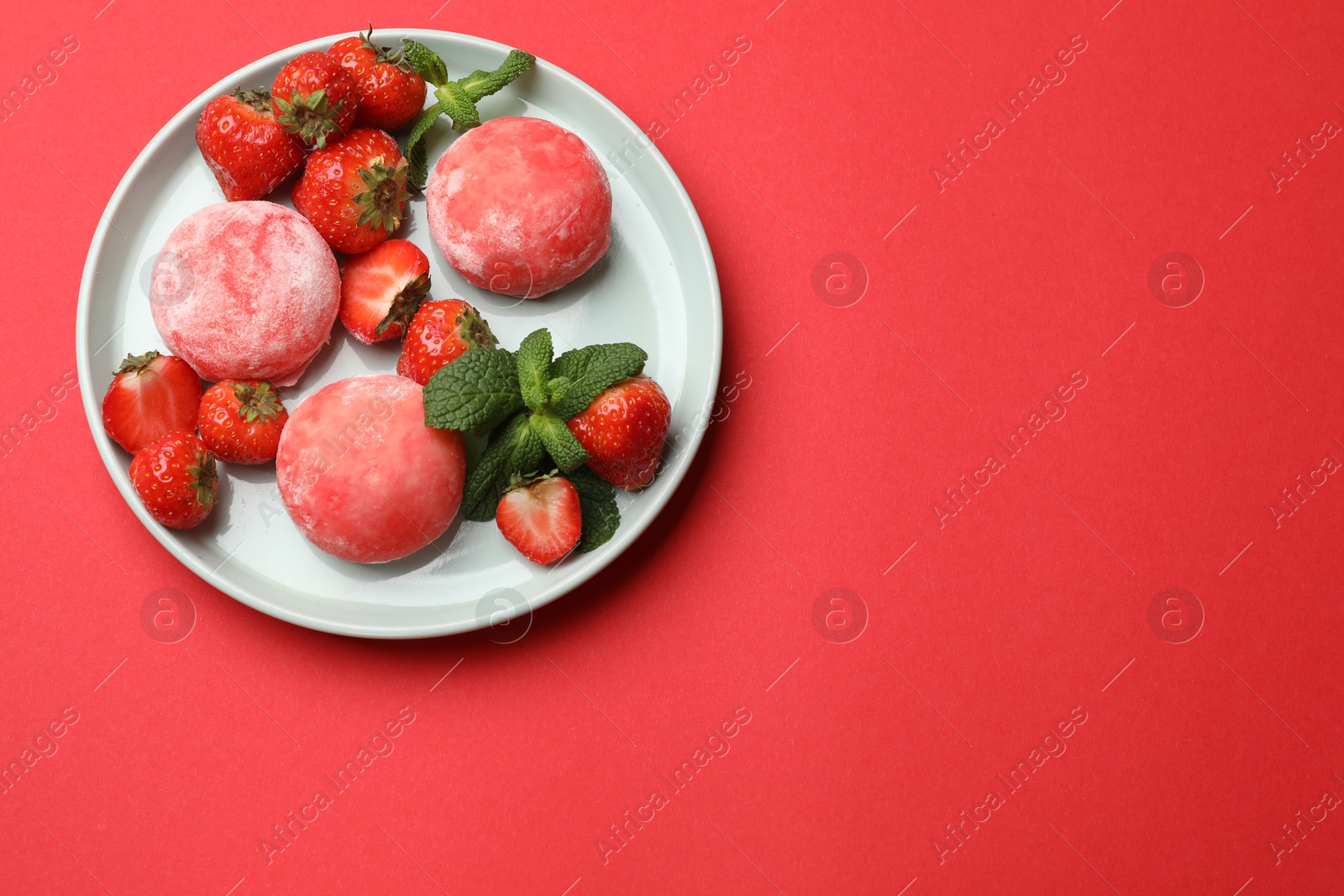 Photo of Delicious mochi, strawberries and mint on red background, top view. Space for text