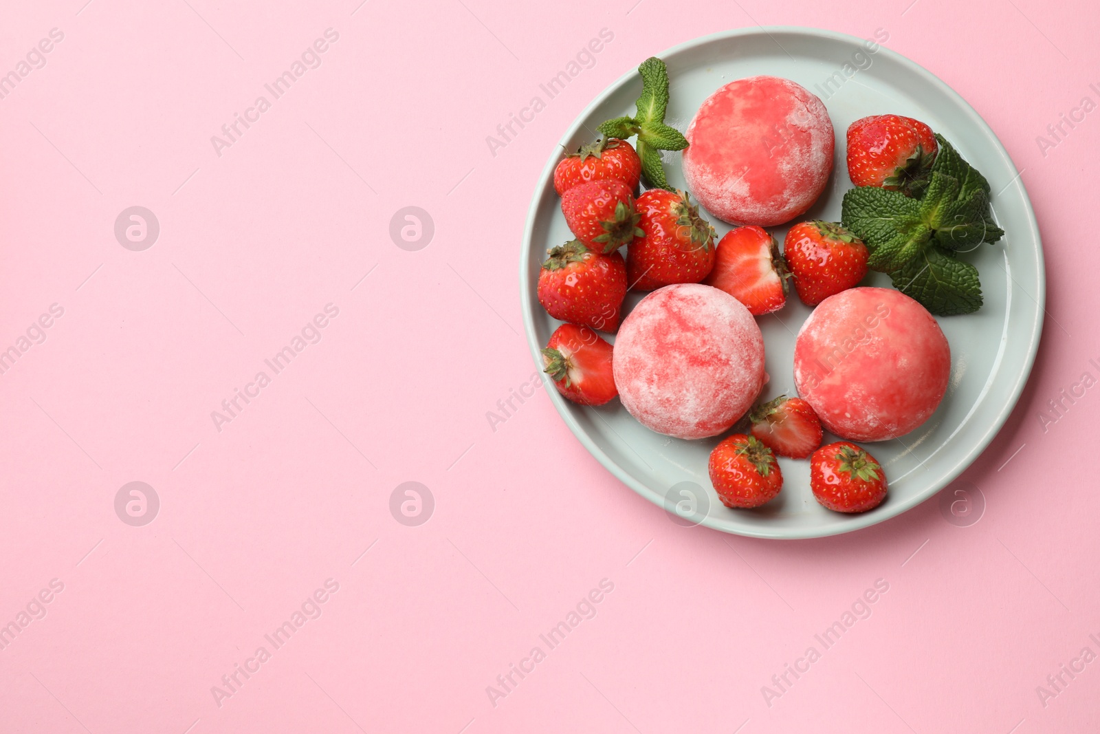 Photo of Delicious mochi, strawberries and mint on pink background, top view. Space for text