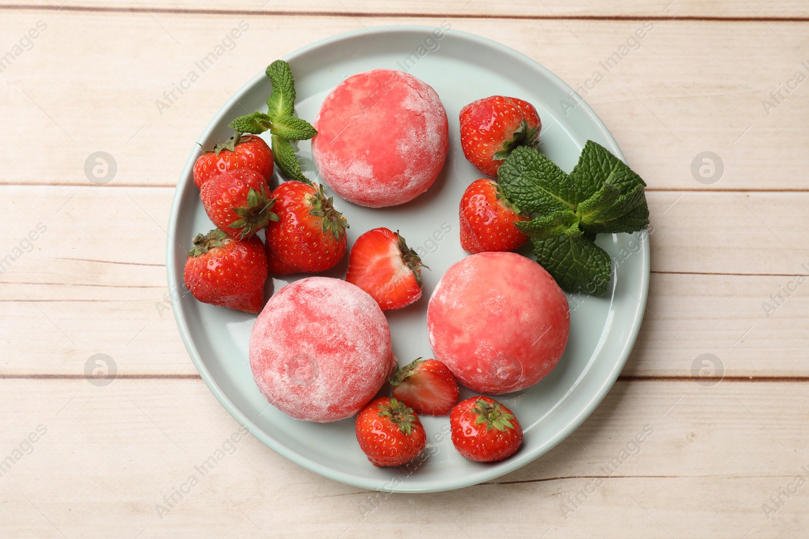 Photo of Delicious mochi, strawberries and mint on wooden table, top view