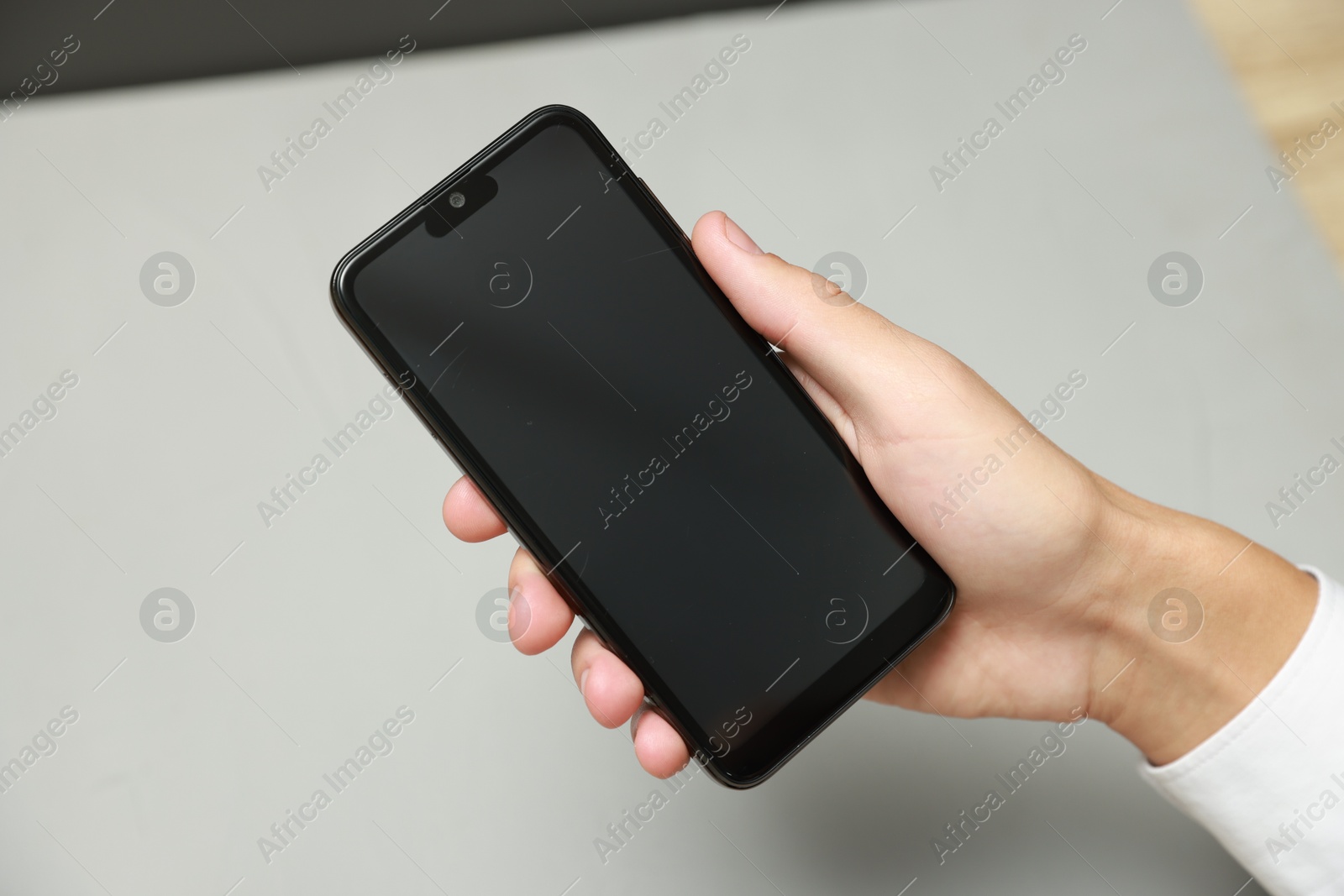 Photo of Man using smartphone with blank screen on grey background, closeup