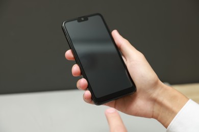 Photo of Man using smartphone with blank screen on blurred background, closeup