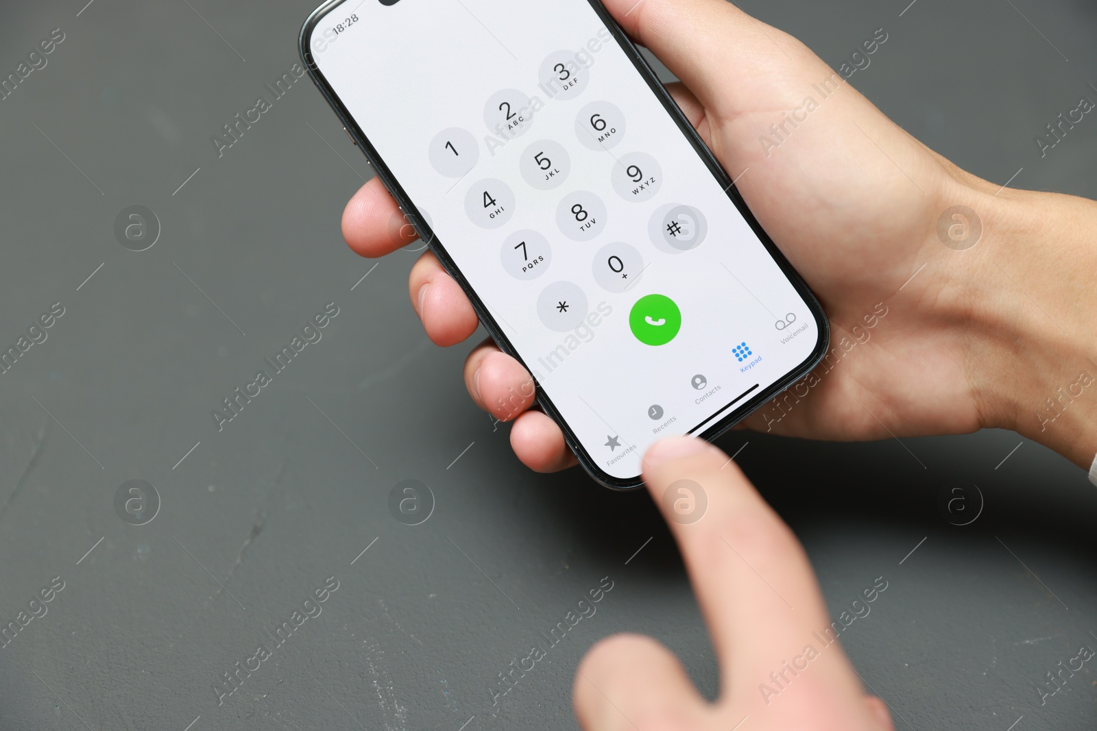 Photo of Man dialing number on smartphone at grey table, closeup. Space for text