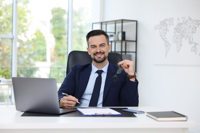 Photo of Portrait of smiling banker at table in office