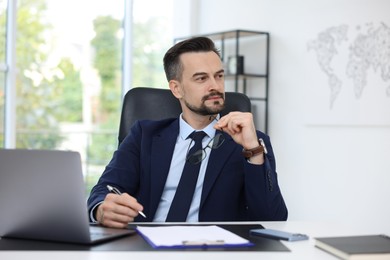 Photo of Handsome banker working at table in office