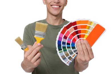 Photo of Young decorator with color palettes and brushes on white background, closeup