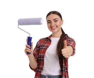 Portrait of young decorator with paint roller showing thumbs up on white background