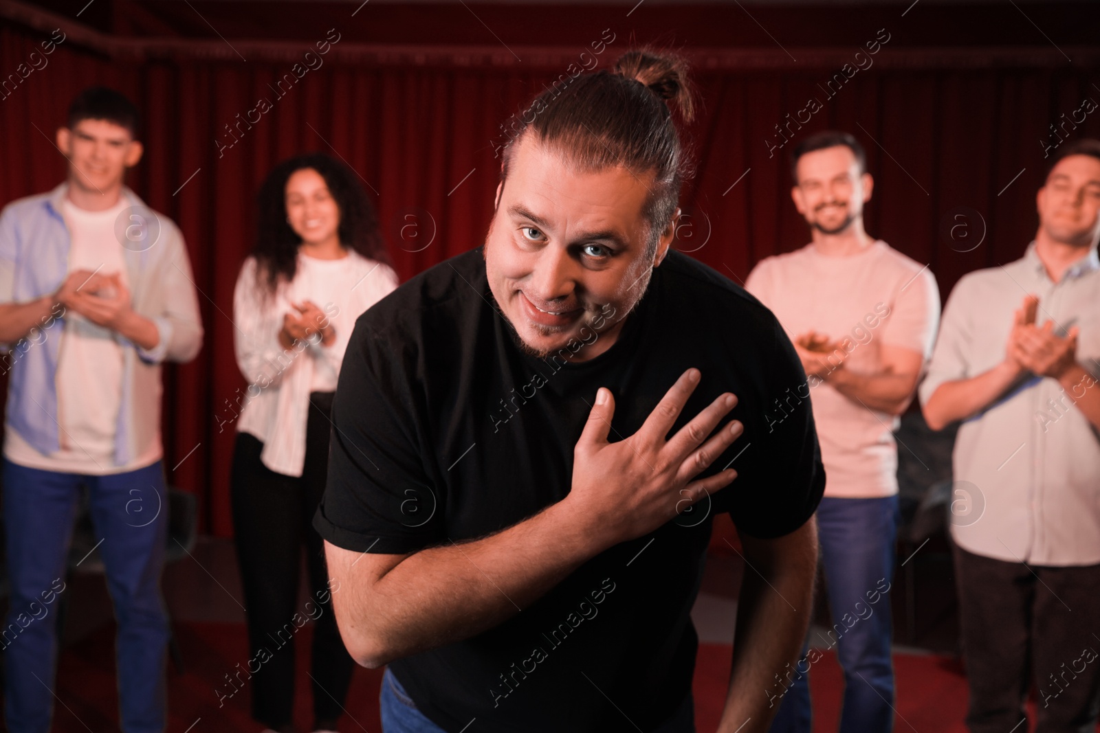 Photo of Professional actors bowing on stage in theatre