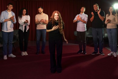 Photo of Professional actors bowing on stage in theatre