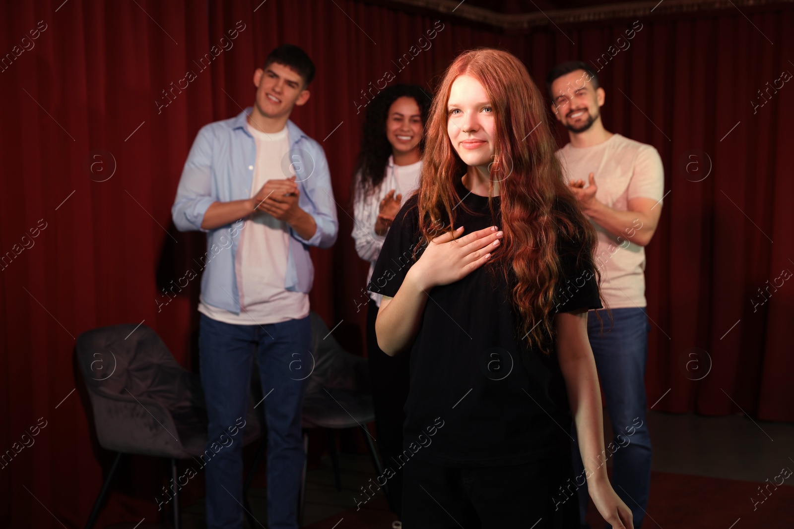 Photo of Professional actors bowing on stage in theatre