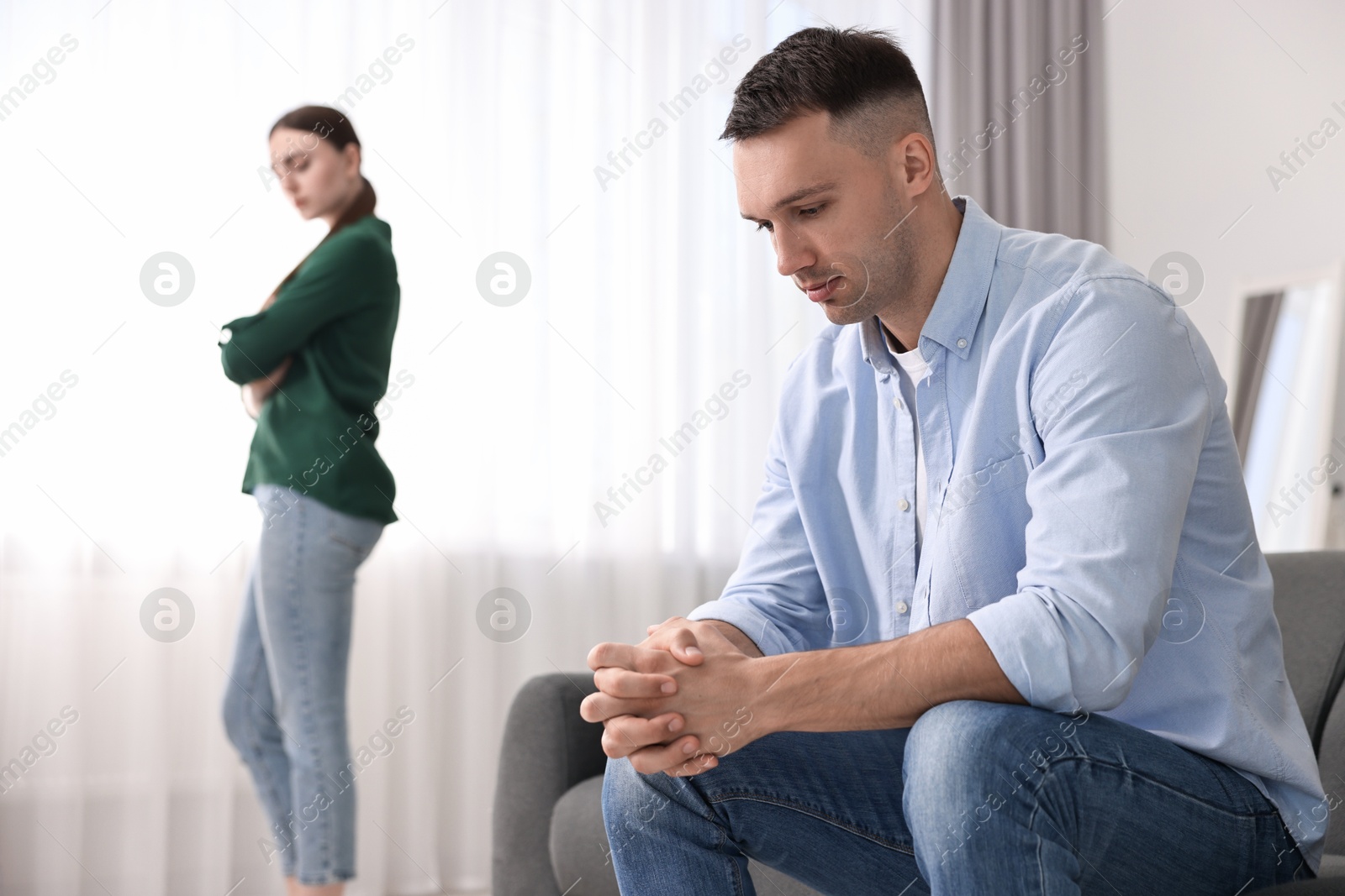 Photo of Offended couple ignoring each other at home, selective focus