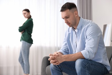 Photo of Offended couple ignoring each other at home, selective focus