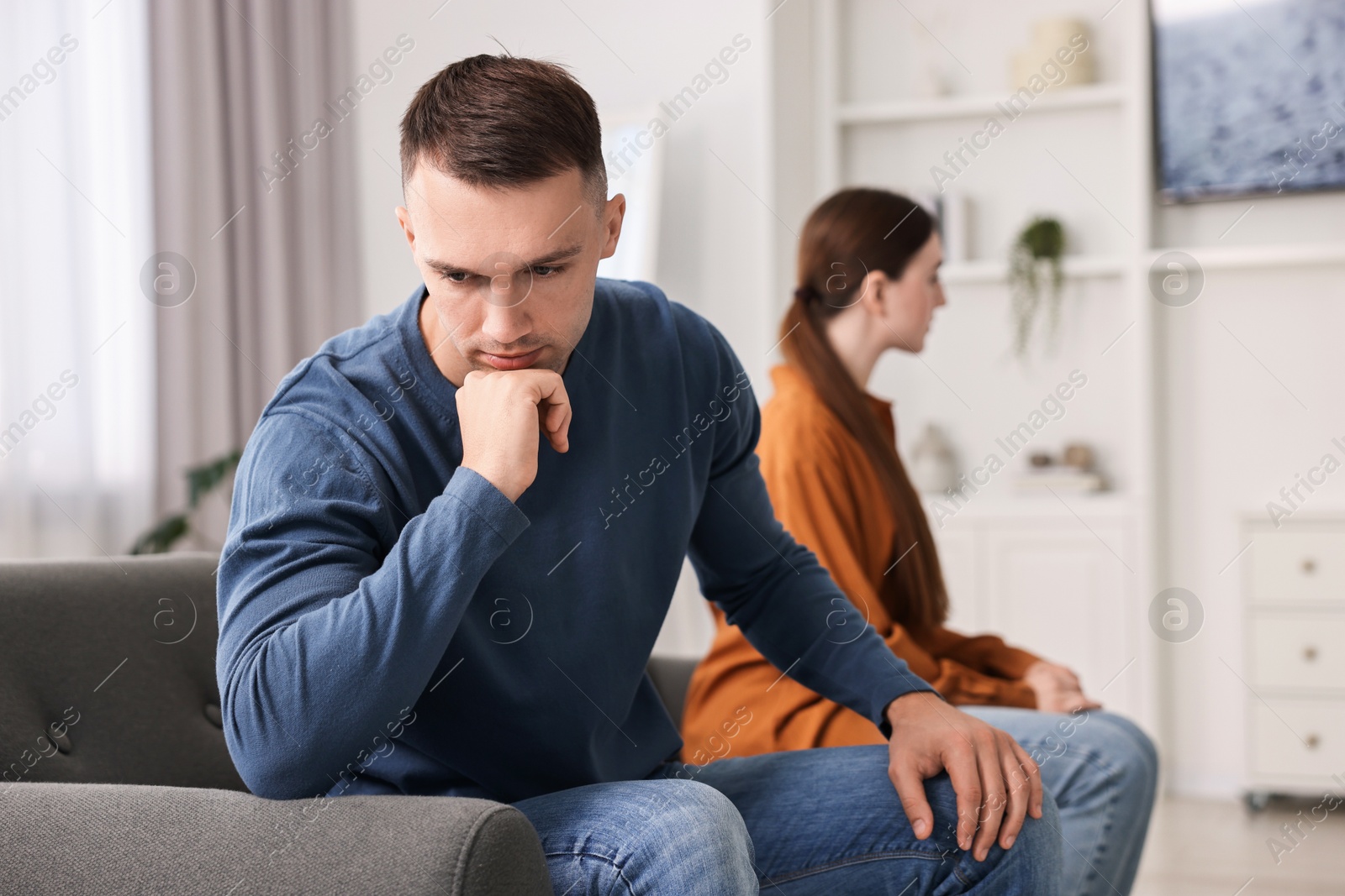 Photo of Offended couple ignoring each other at home, selective focus