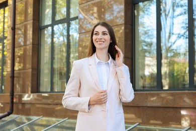 Photo of Portrait of young woman wearing stylish suit outdoors