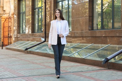 Photo of Portrait of young woman wearing stylish suit outdoors