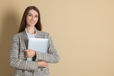 Photo of Portrait of smiling banker with laptop on beige background. Space for text