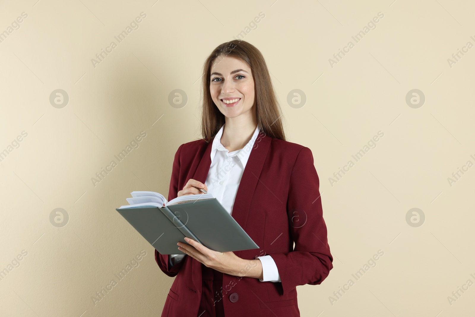 Photo of Portrait of smiling banker with book on beige background