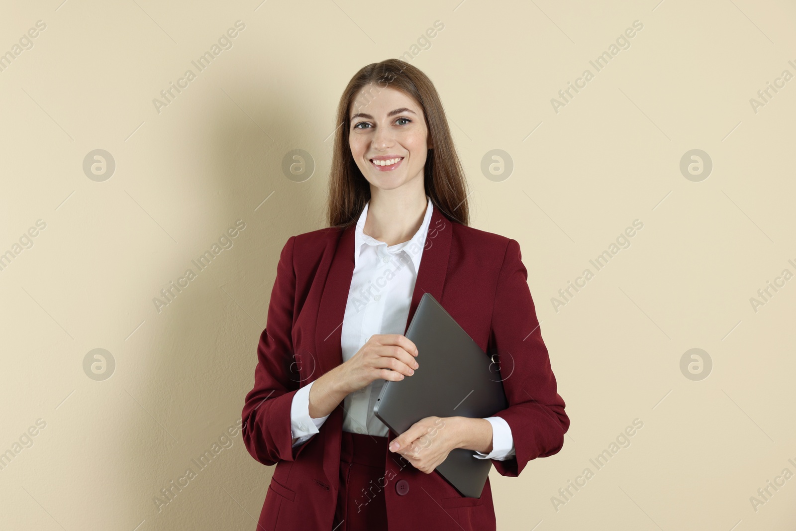 Photo of Portrait of smiling banker with laptop on beige background