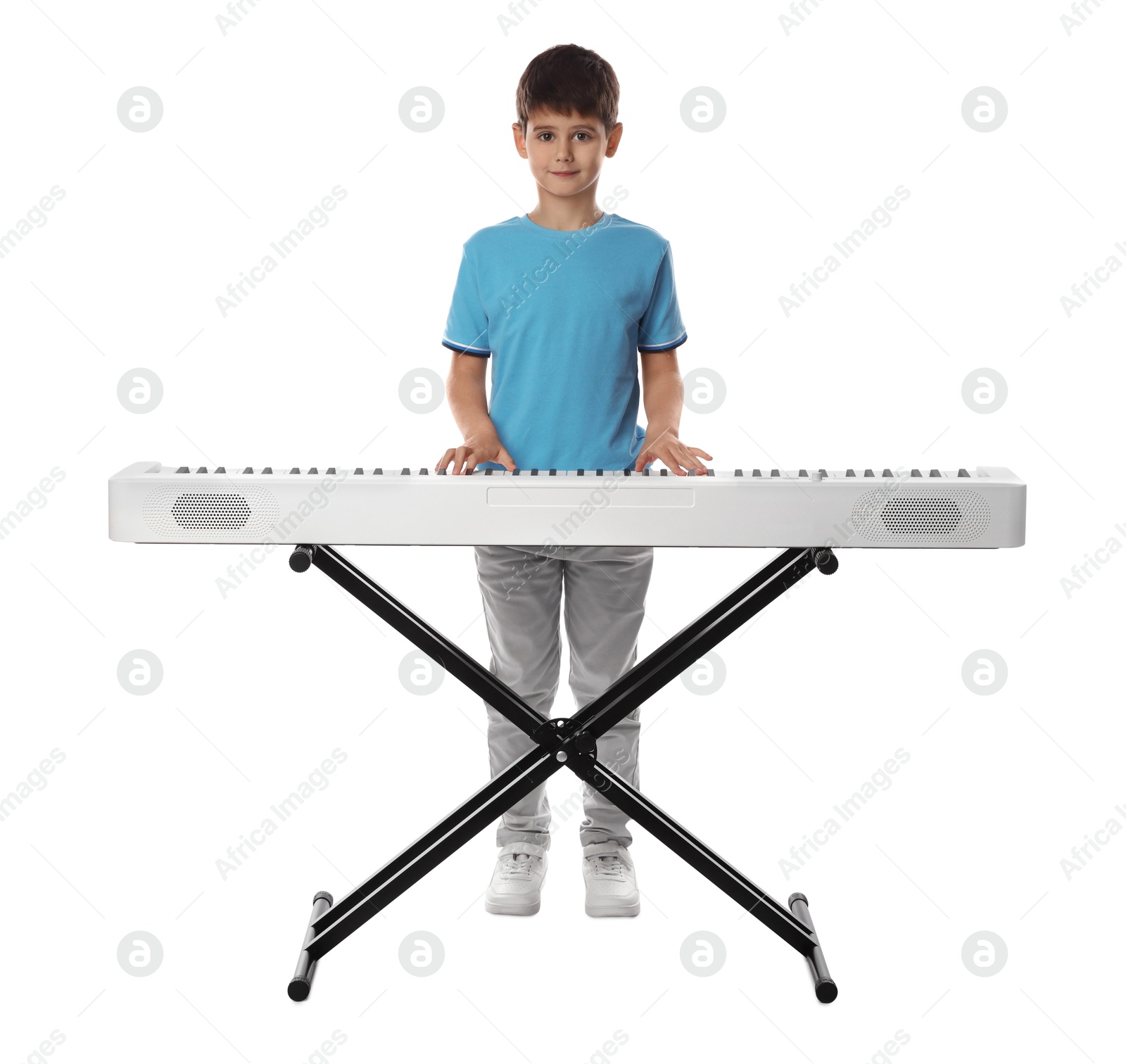 Photo of Cute boy playing synthesizer on white background