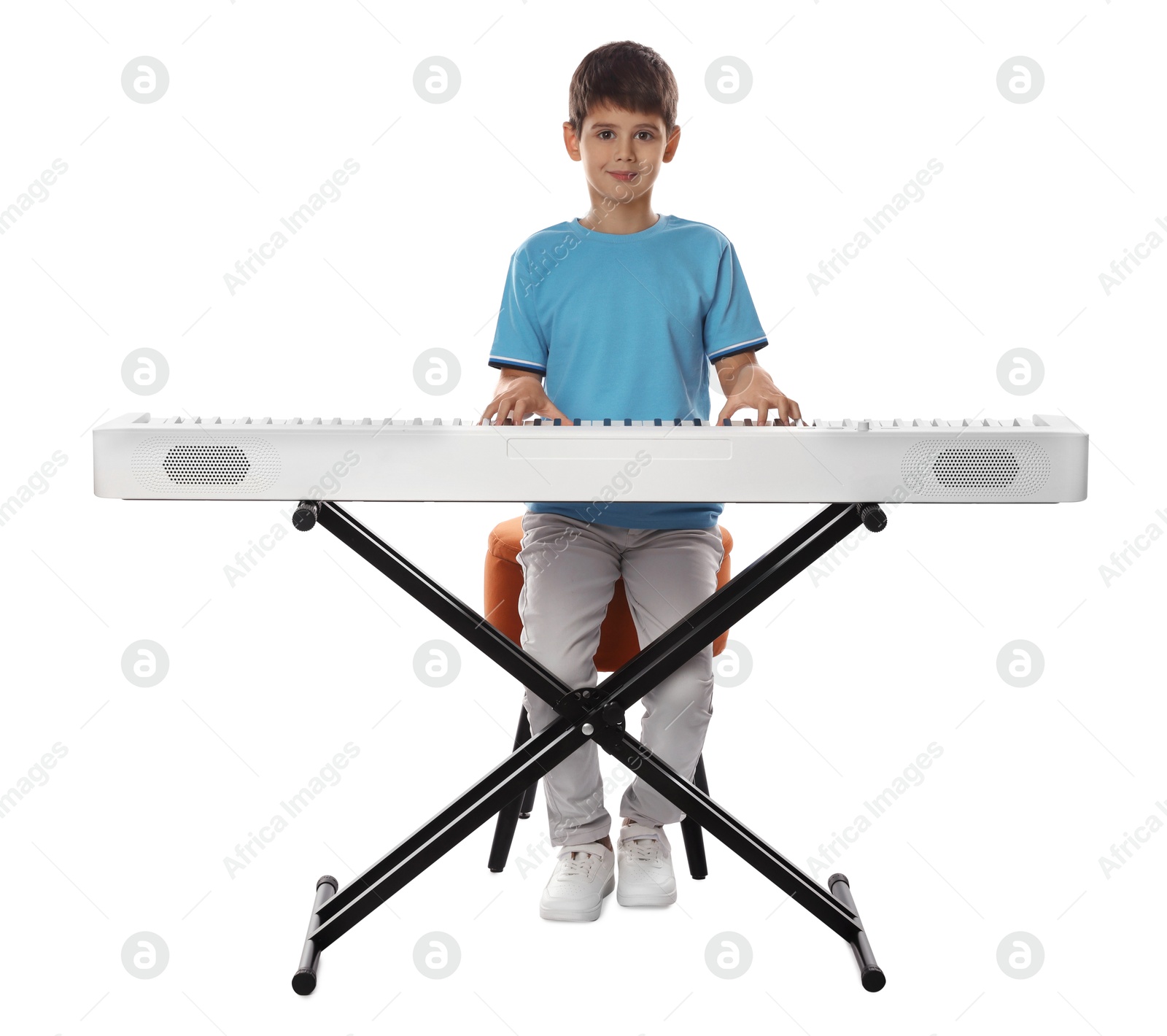 Photo of Cute boy playing synthesizer on white background