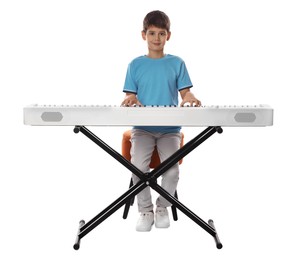 Photo of Cute boy playing synthesizer on white background