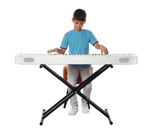 Cute boy playing synthesizer on white background