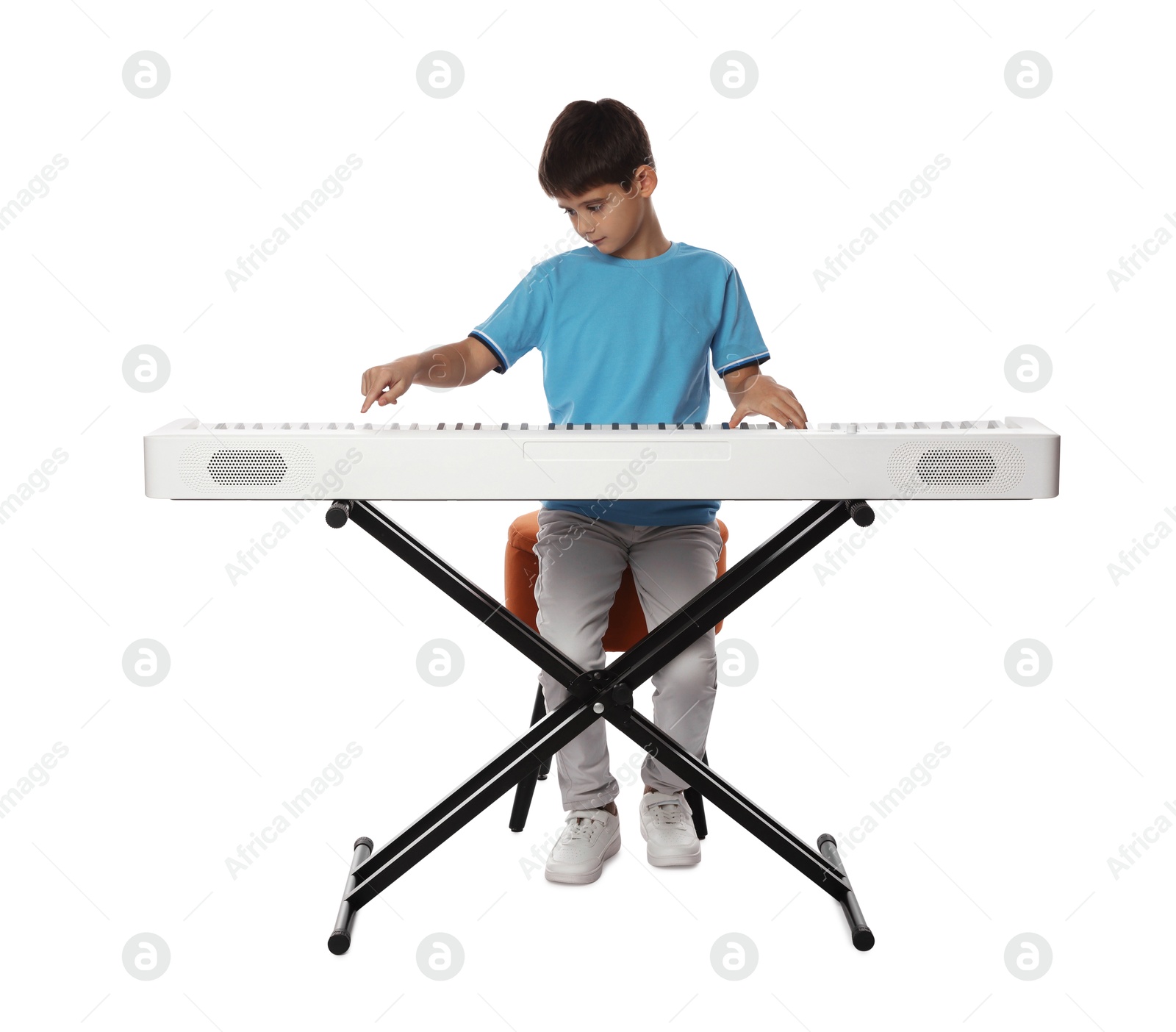 Photo of Cute boy playing synthesizer on white background