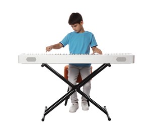 Cute boy playing synthesizer on white background