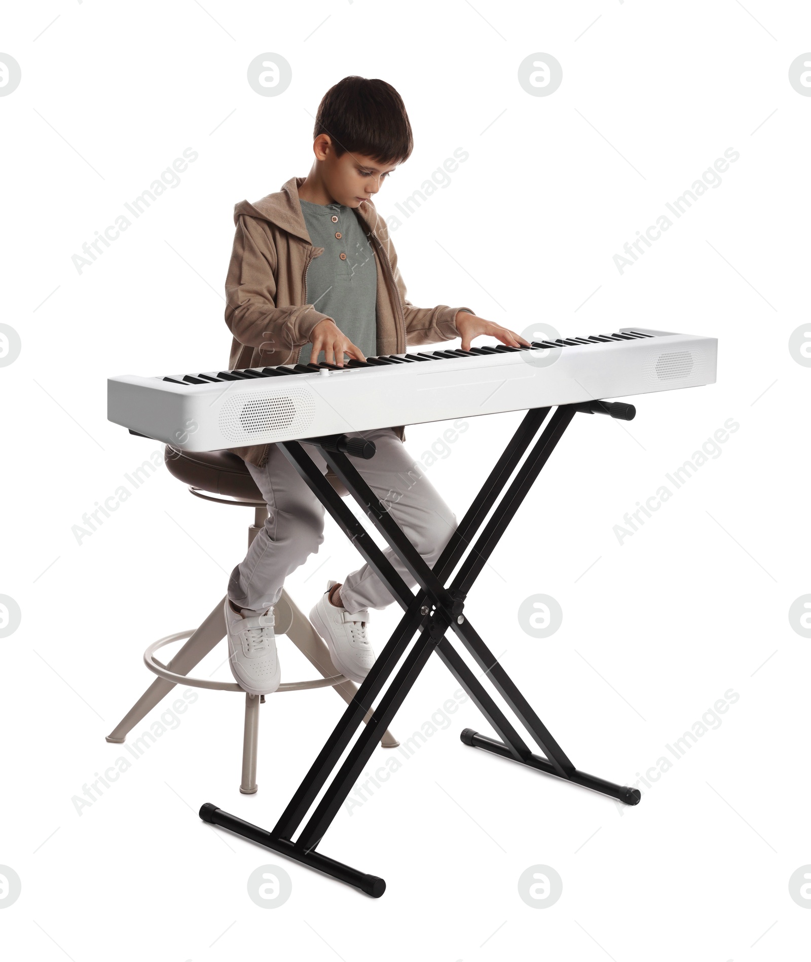 Photo of Cute boy playing synthesizer on white background