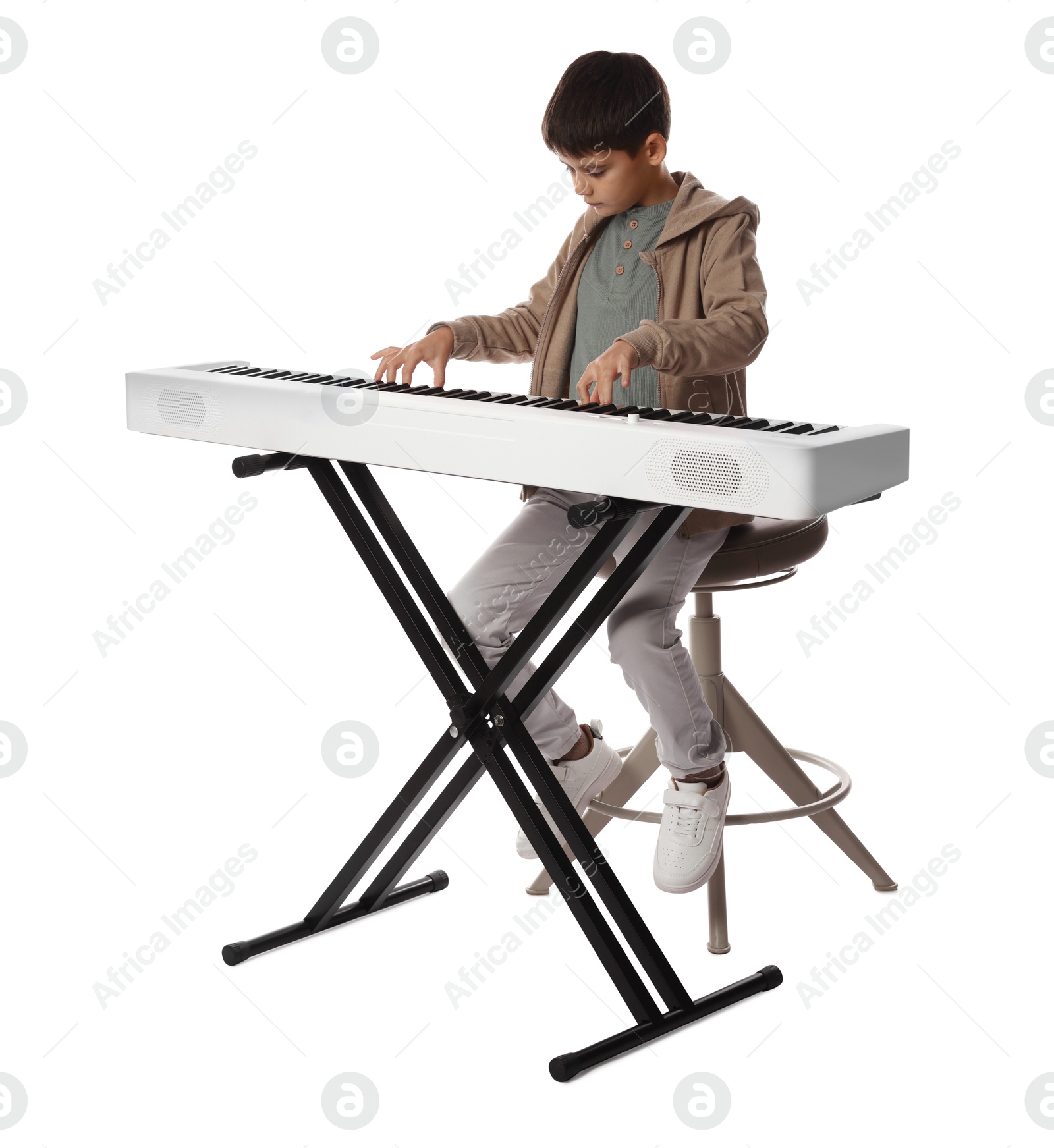 Photo of Cute boy playing synthesizer on white background