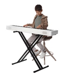 Photo of Cute boy playing synthesizer on white background