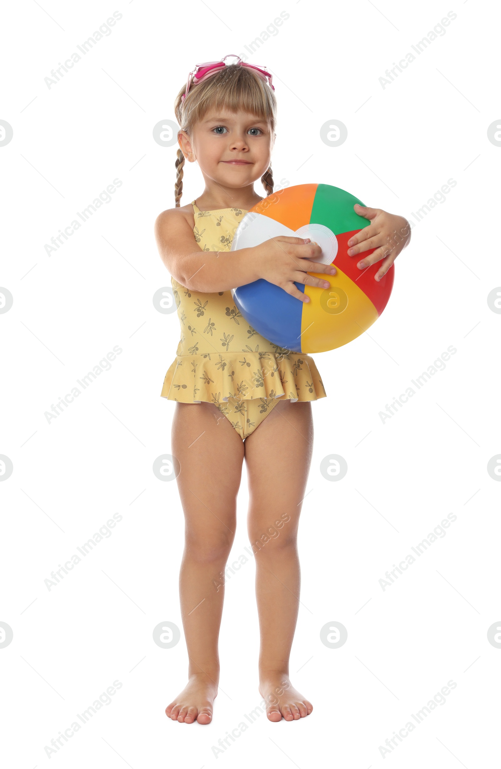 Photo of Cute little girl in swimsuit with inflatable ball and swim goggles on white background