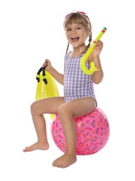 Cute little girl in swimsuit with inflatable ball and snorkeling equipment on white background