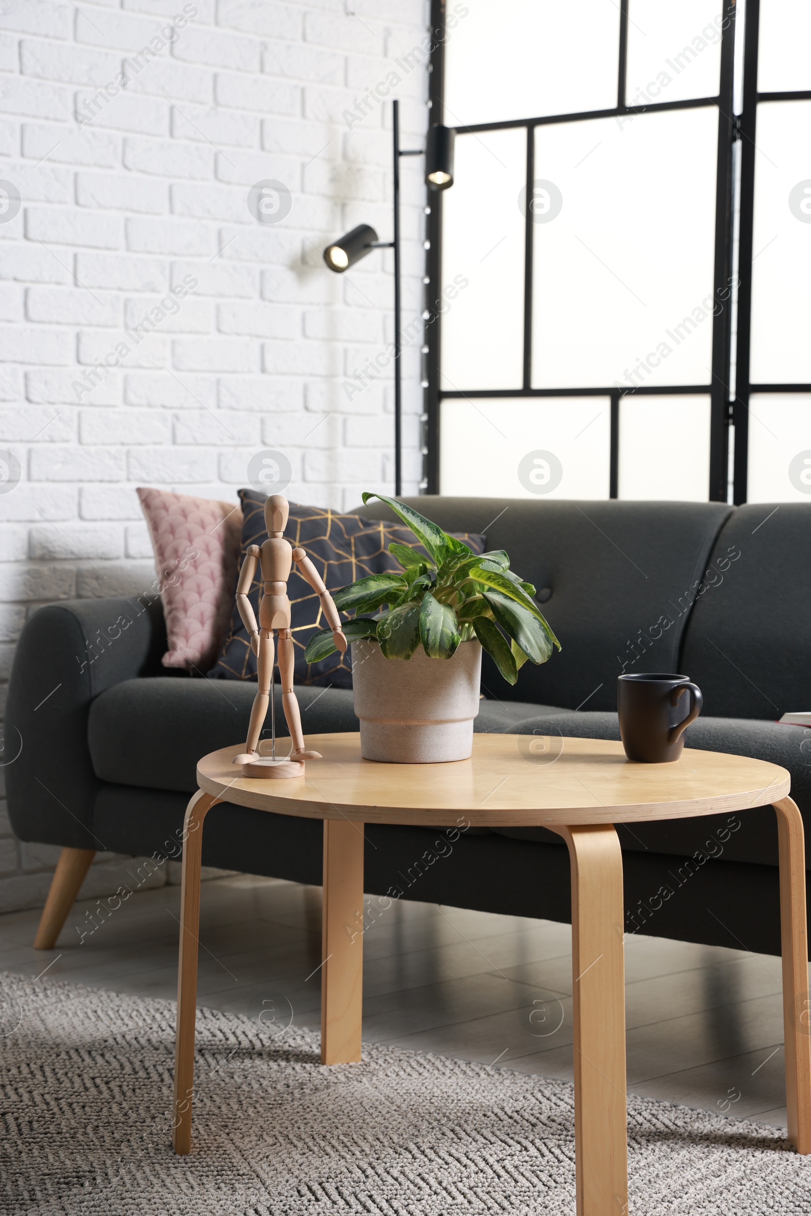 Photo of Coffee table, soft sofa and lamp in stylish living room. Interior design