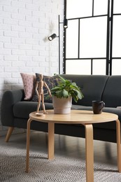 Photo of Coffee table, soft sofa and lamp in stylish living room. Interior design