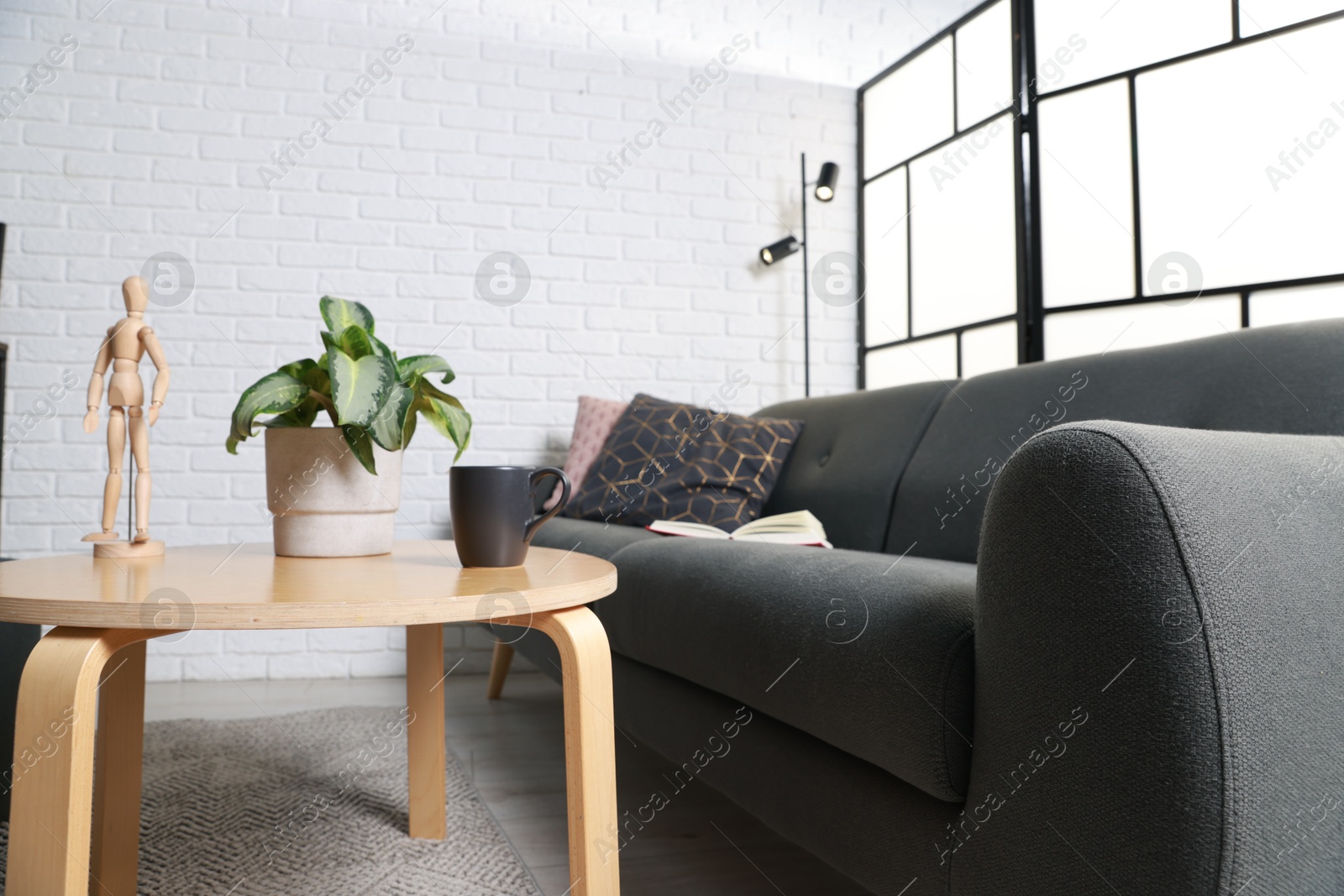 Photo of Coffee table and soft sofa in stylish living room. Interior design