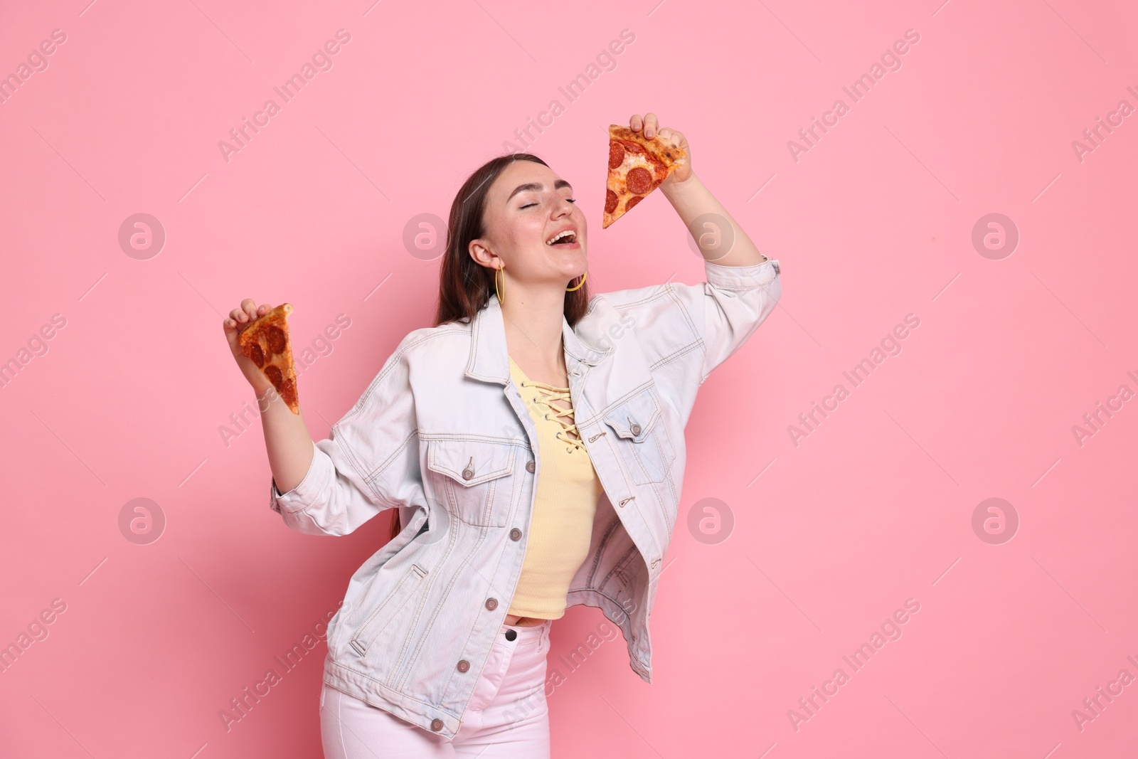 Photo of Beautiful woman with delicious pizza on pink background