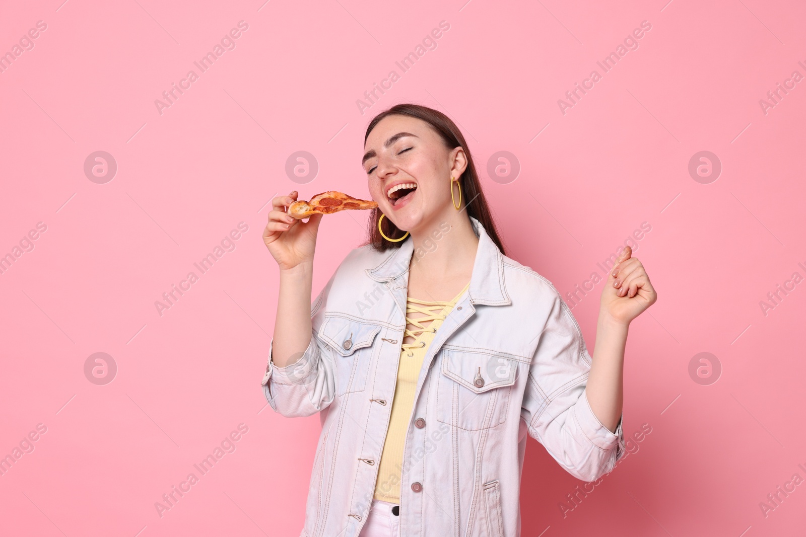 Photo of Beautiful woman with delicious pizza on pink background