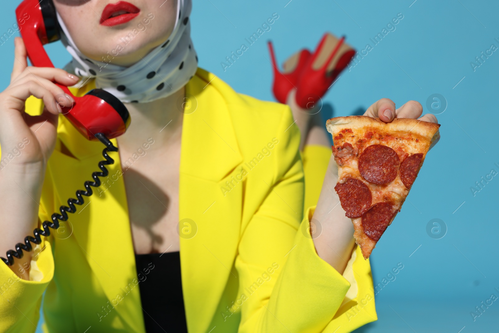 Photo of Woman with delicious pizza and telephone on light blue background, closeup