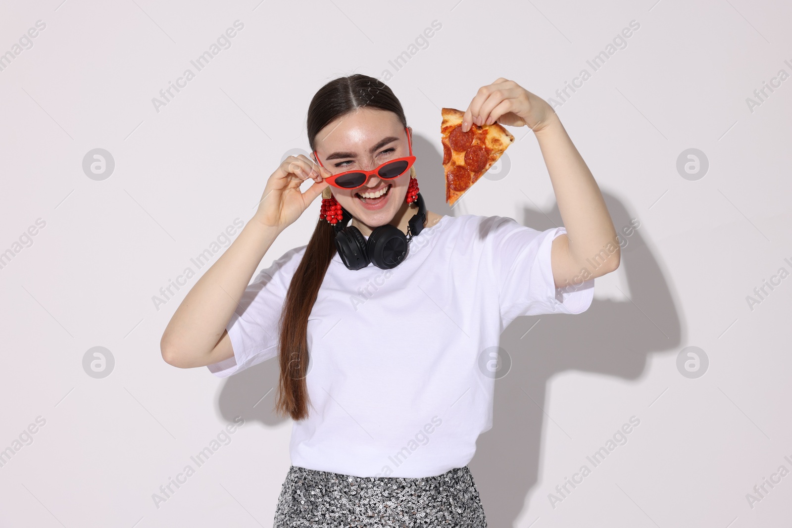 Photo of Woman in sunglasses with piece of pizza on white background