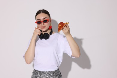 Photo of Woman in sunglasses with piece of pizza on white background, space for text