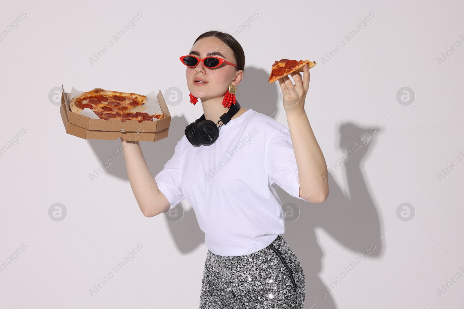 Photo of Woman in sunglasses with delicious pizza on white background